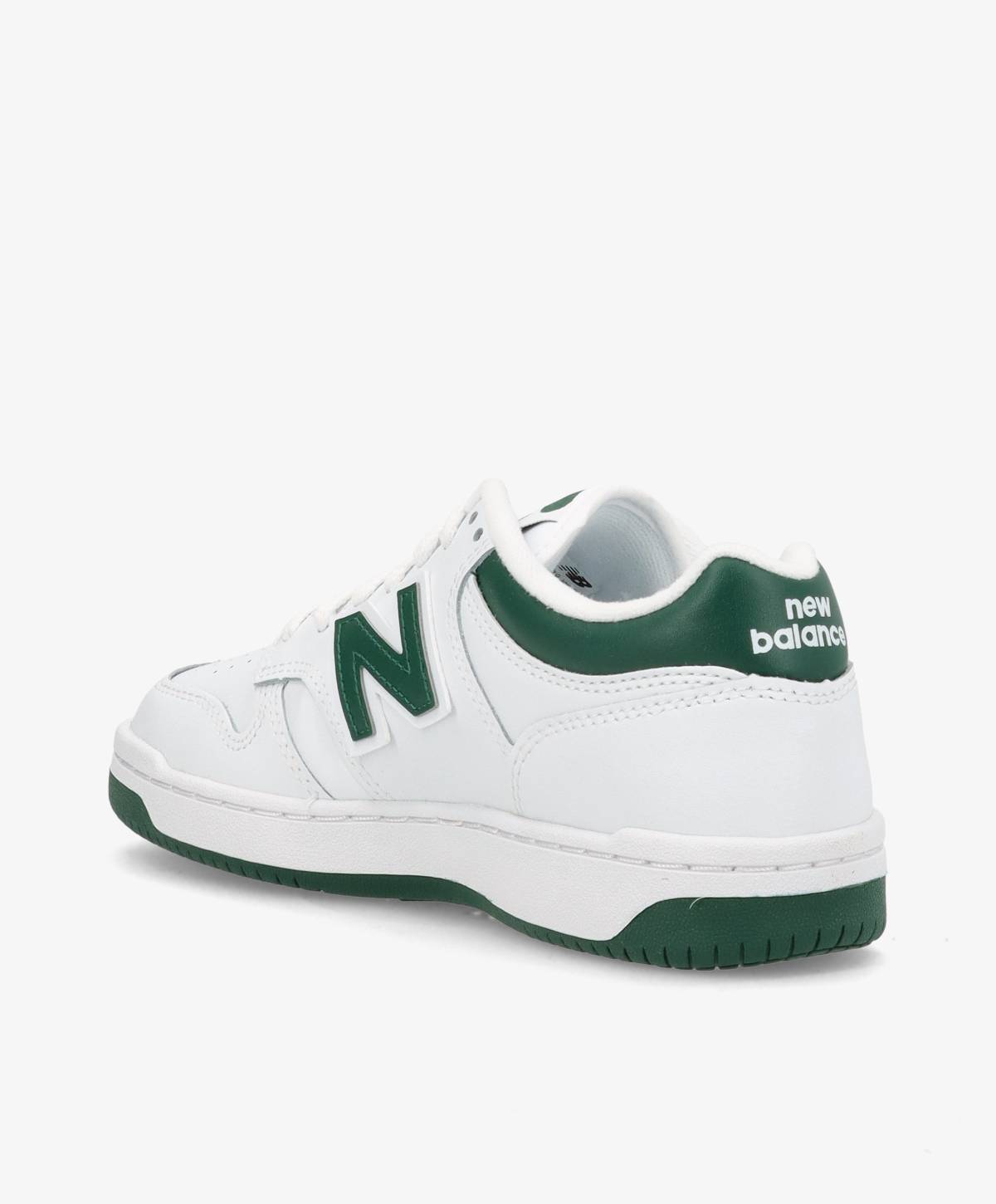 Hvid og grøn New Balance sneaker set fra siden med logo på hælen.