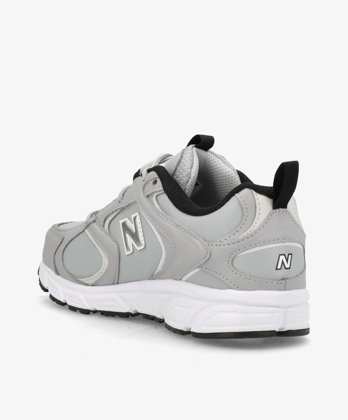 Grå og hvid sneaker set fra siden med sort sål og sort detalje på hælen.