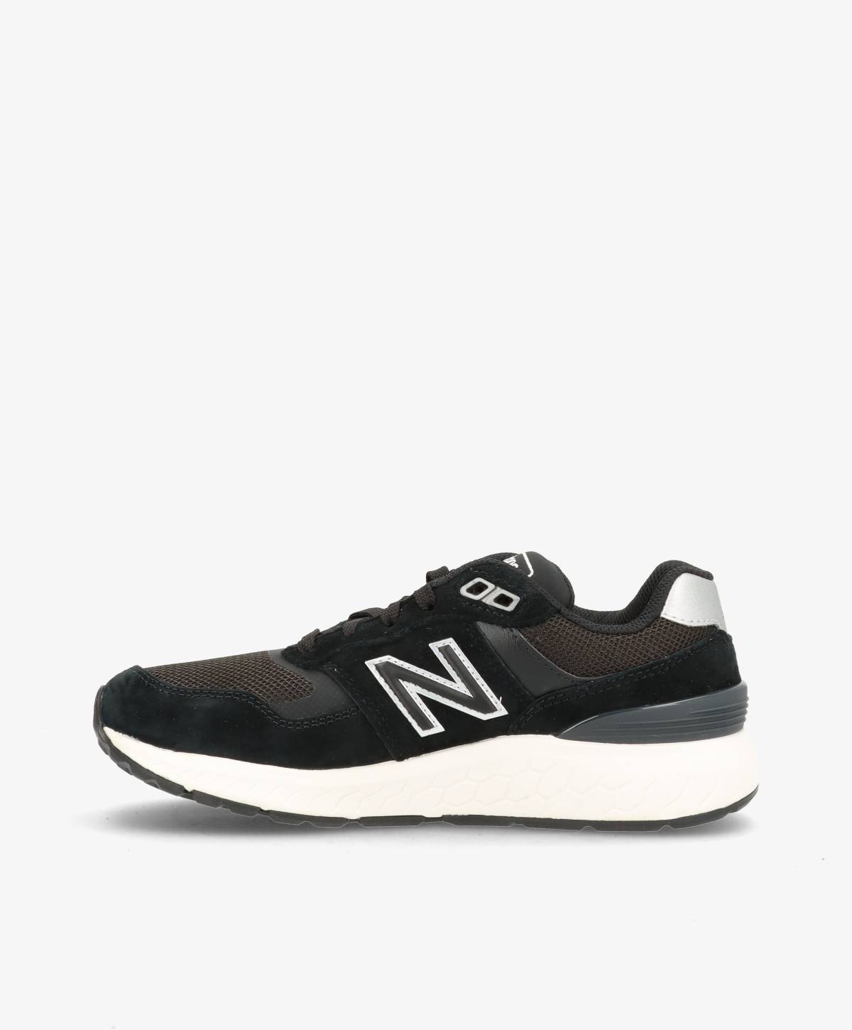 Sort og hvid sneaker med New Balance-logo på siden, set fra siden mod en hvid baggrund.