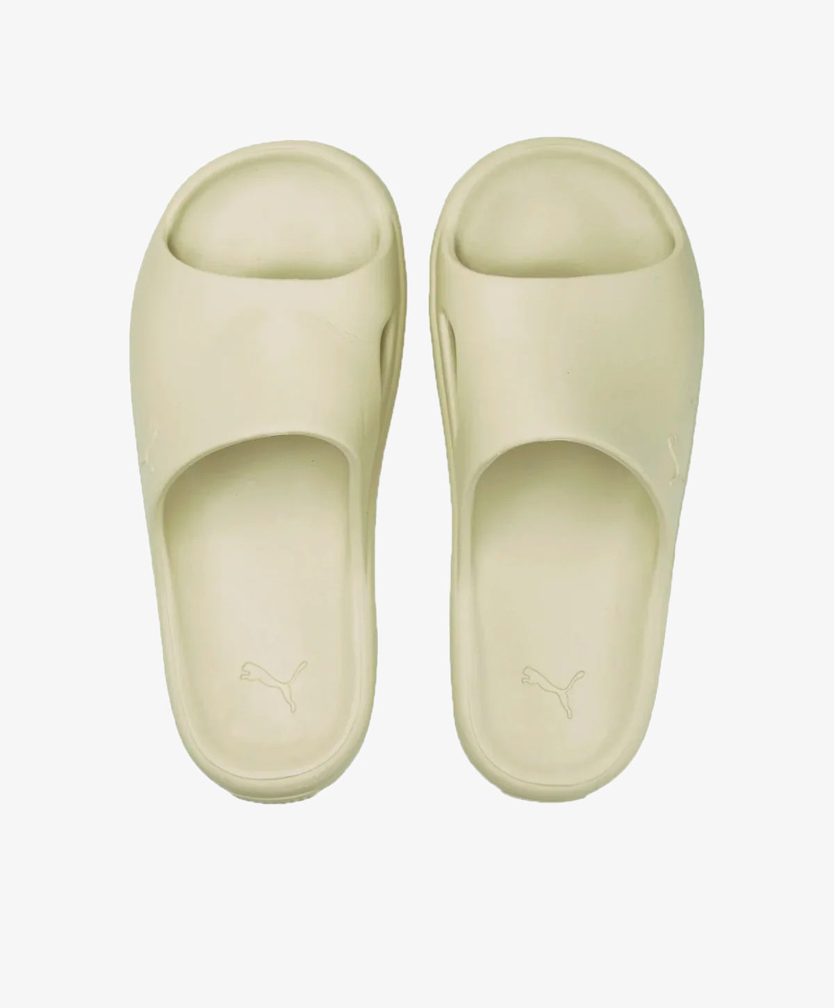 Beige sandaler med åben tå og en bred rem over foden, set oppefra.