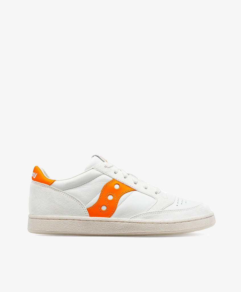 Hvide Saucony sneakers med orange detaljer på siden og hælkappen.