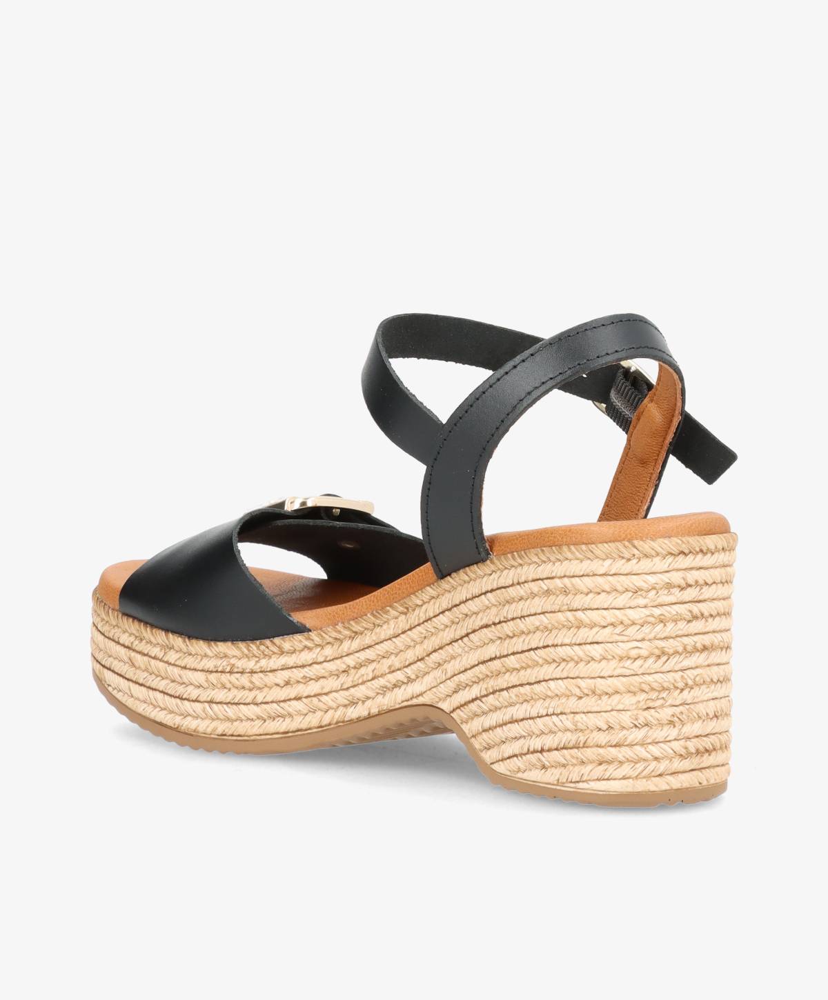 Sort sandal med kilehæl og flettet sål, set fra siden.