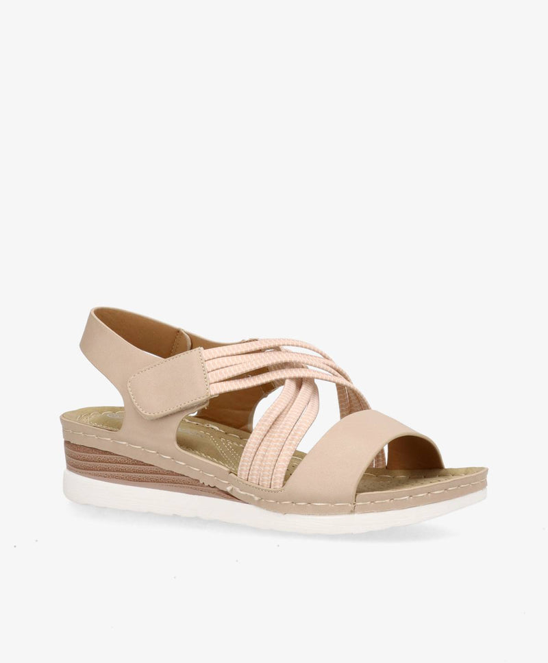 Beige sandal med elastiske stropper og lav kilehæl.