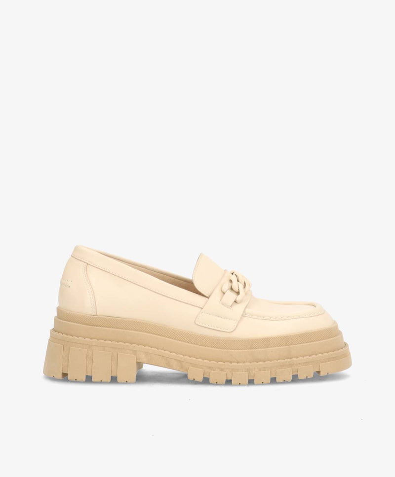 Beige loafers med tyk, rillet sål og dekorativ rem på toppen, set fra siden mod en hvid baggrund.