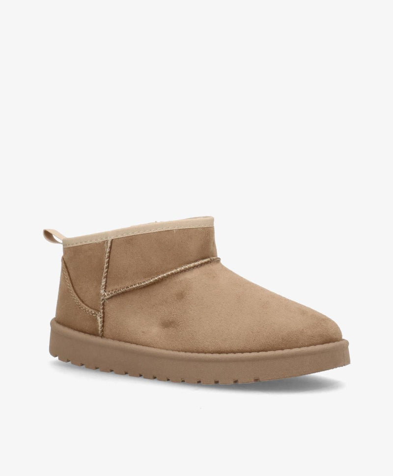Beige ankelstøvle i ruskind med flad sål og strop bagpå.