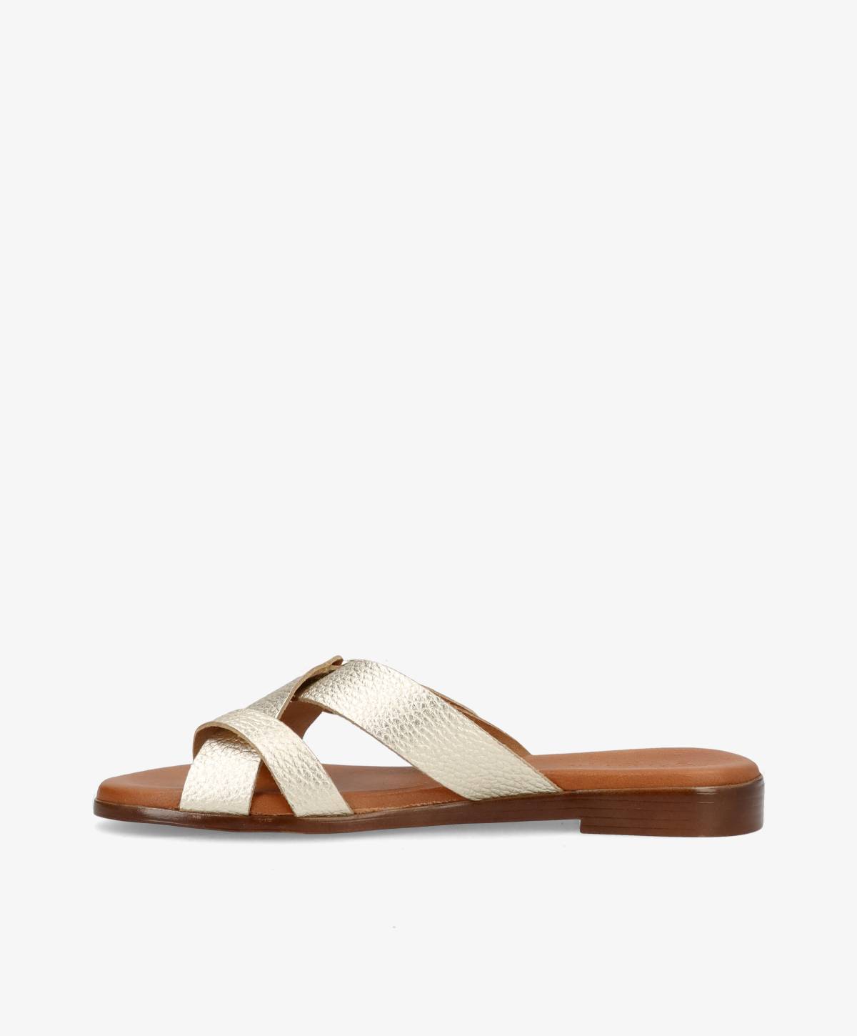 Beige lædersandal med krydsede remme og flad brun sål på hvid baggrund.