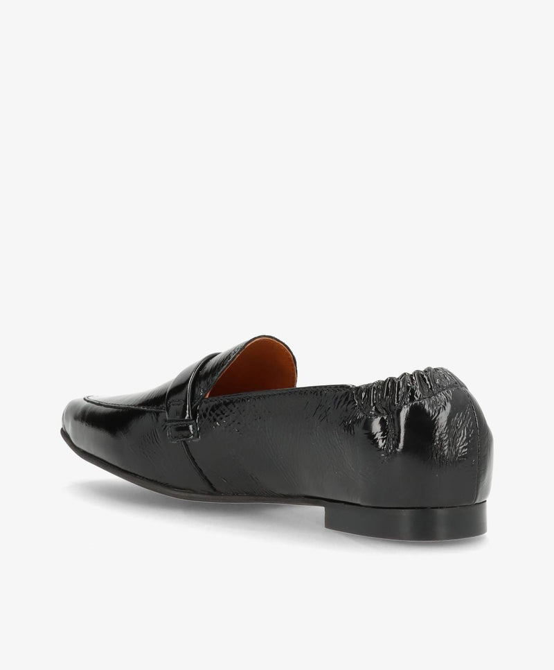 Sort lædersko med lav hæl og elastisk detalje bagpå, set fra siden.