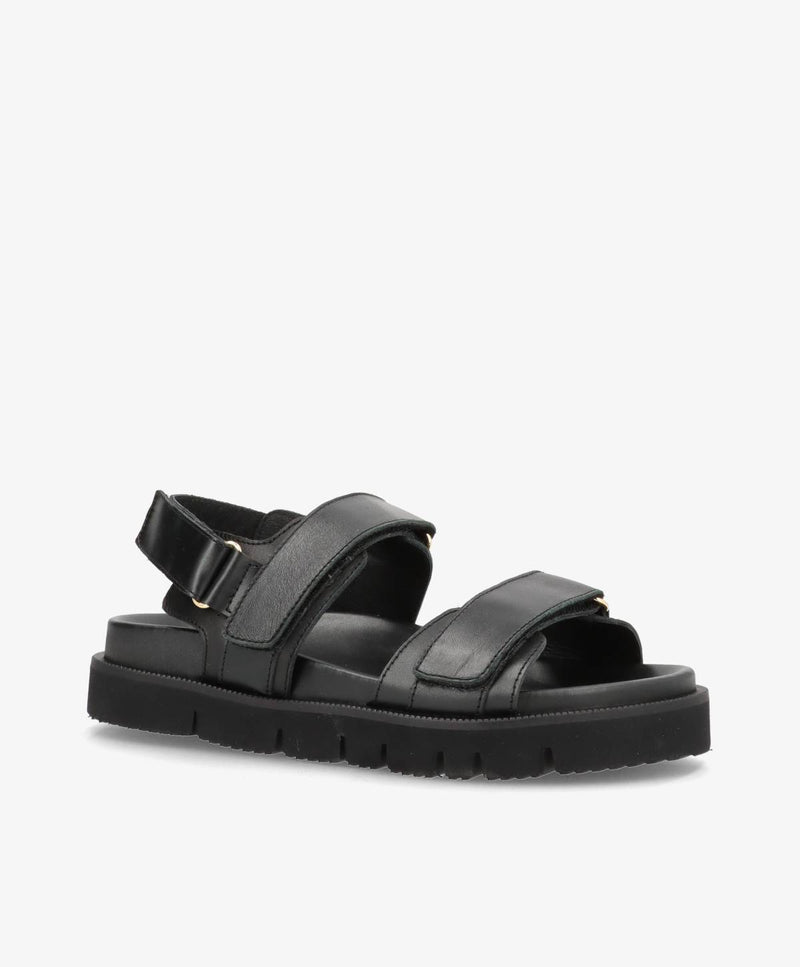 Sort damesandal med justerbare stropper og tyk sål.