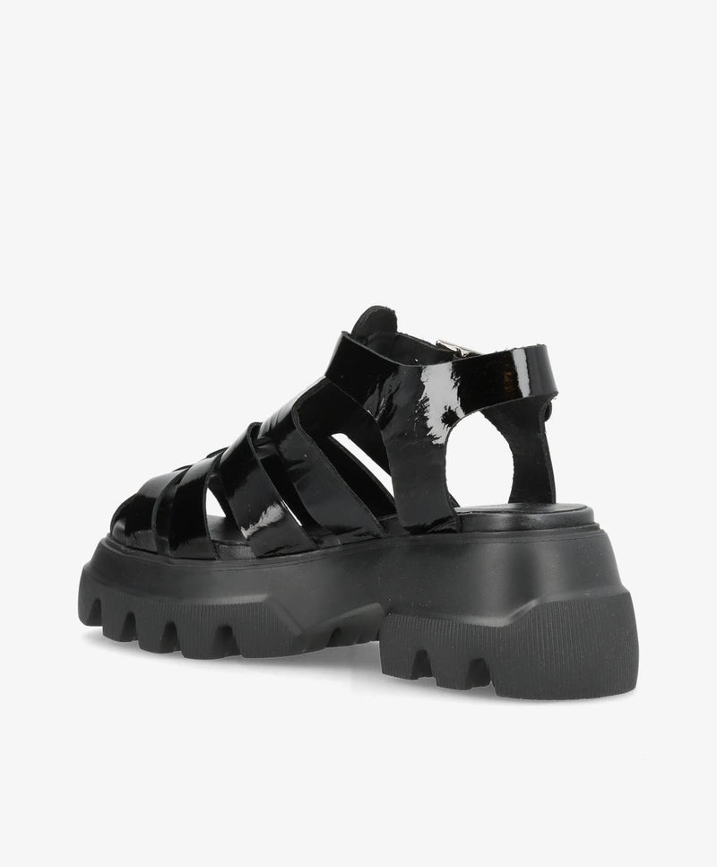 Sort sandal med tyk, rillet sål og flere remme i blankt materiale.