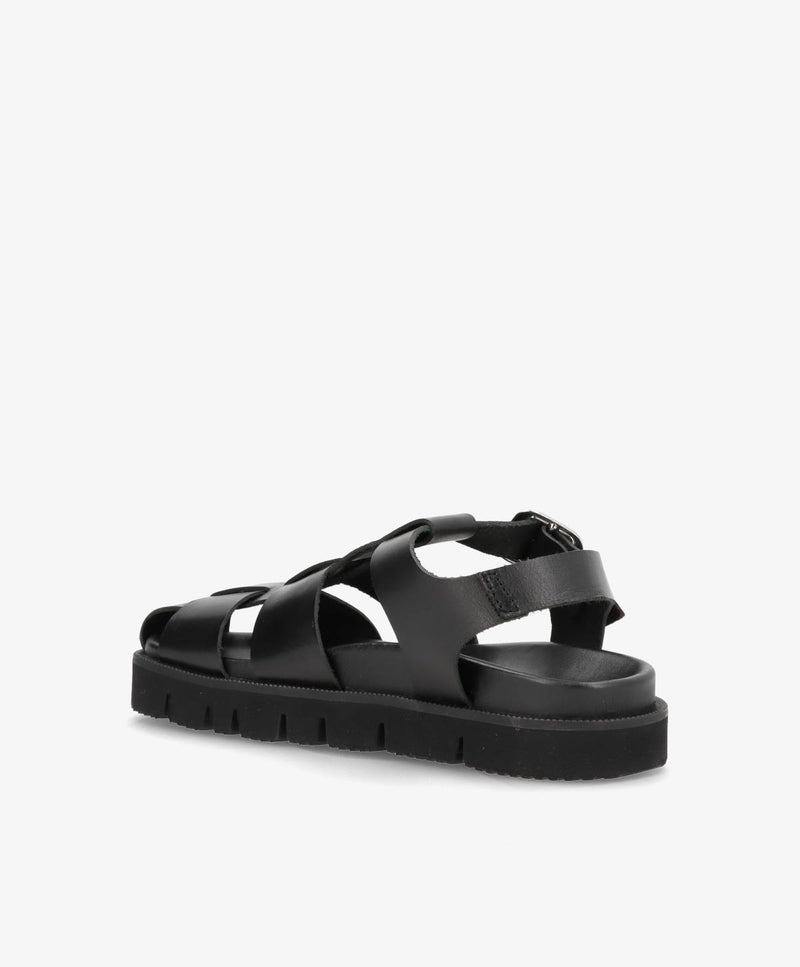 Sort damesandal med remme og flad sål, set fra siden.
