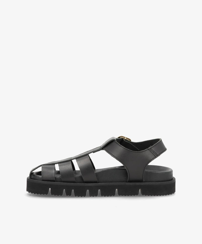 Sort damesandal med remme og flad sål, set fra siden.